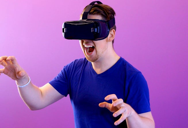 A person wearing a VR headset interacts with a digital environment using hand gestures, set against a vibrant purple background.