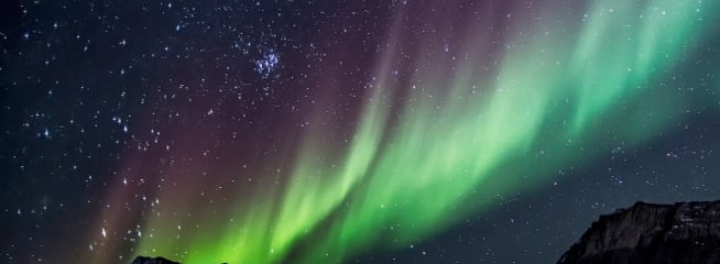 Pocket Borealis – A mesmerizing display of the Northern Lights, with vibrant green and purple lights in the night sky.